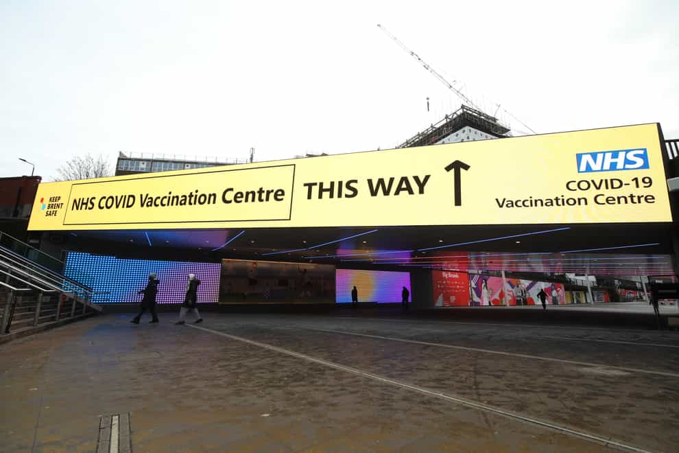 An information sign outside Wembley station gives direction to the NHS Covid Vaccine Centre at the Olympic Office Centre, Wembley (Yui Mok/PA)