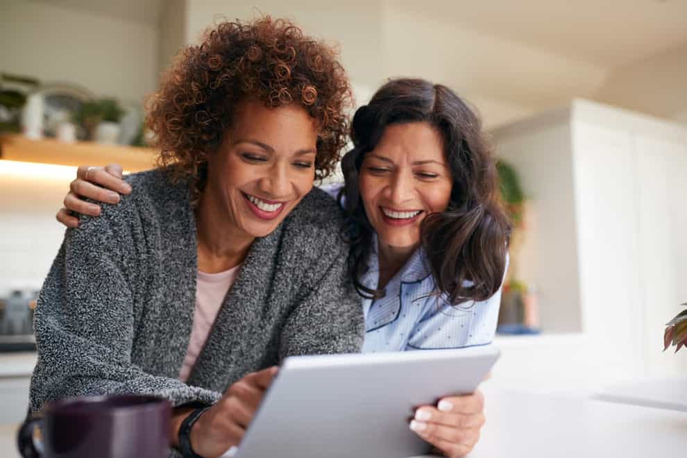 Lesbian couple looking at a tablet device together at home