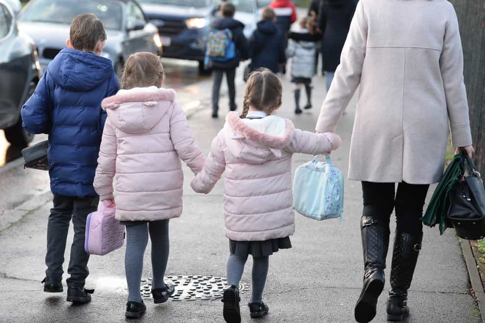 Parents walk their children to school