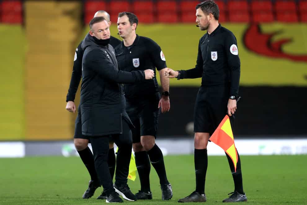 Wayne Rooney, left, speaks to the match officials after the game