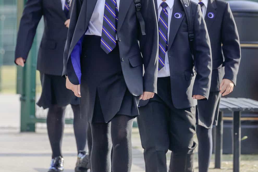 Pupils wear protective face masks as they walk to school