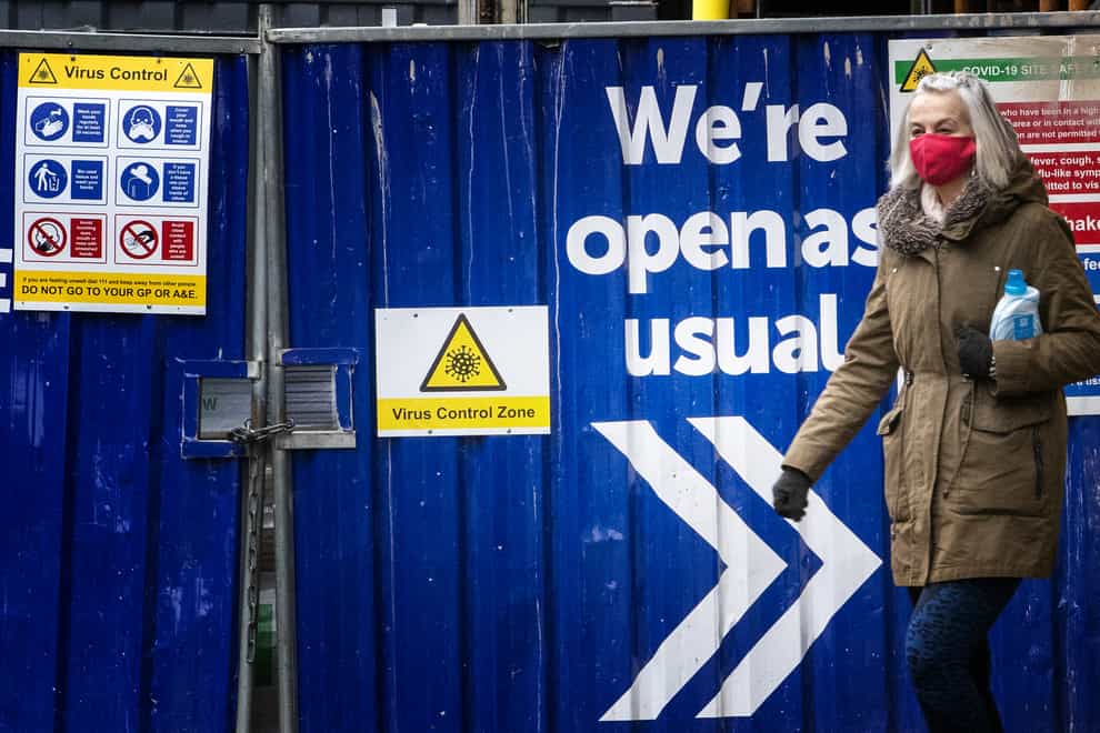 A shopper walks past a coronavirus sign in Edinburgh