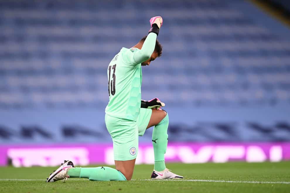 Manchester City goalkeeper Zack Steffen knees and raises his fist in support of the Black Lives Matter movement