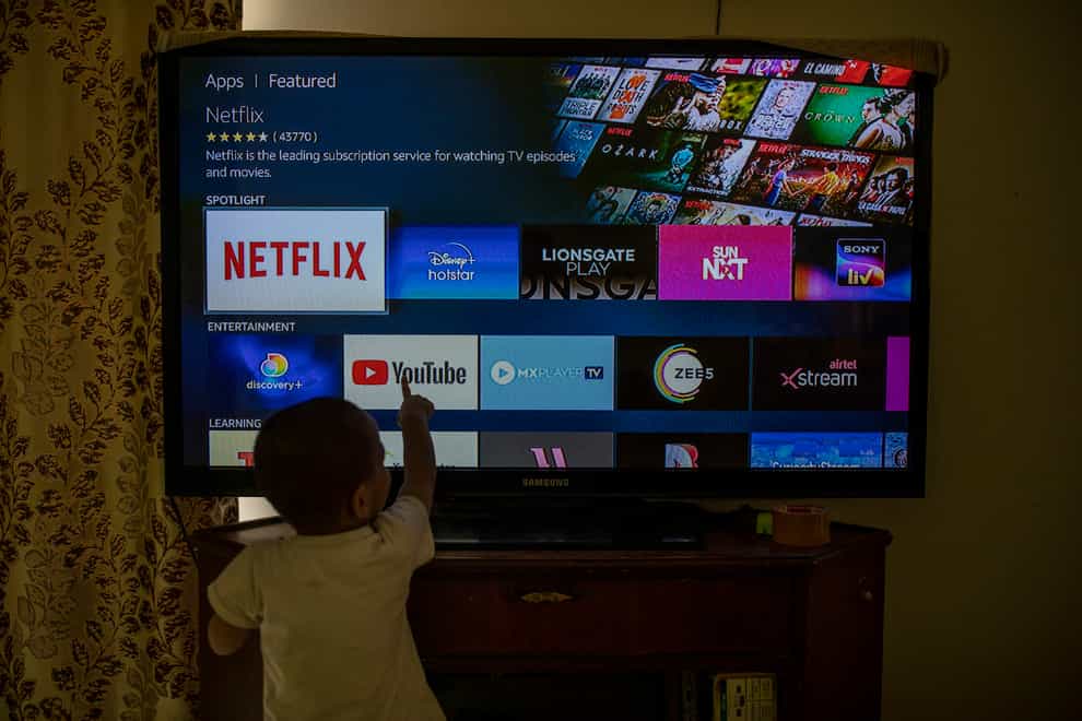 A child touches a TV screen