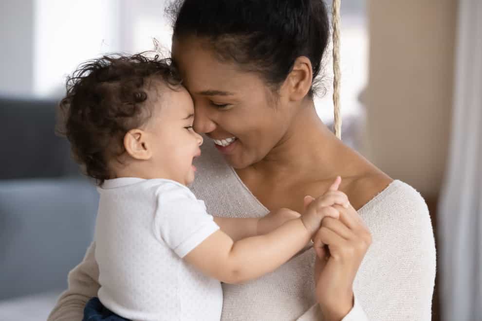 Smiling mixed race mum holding baby