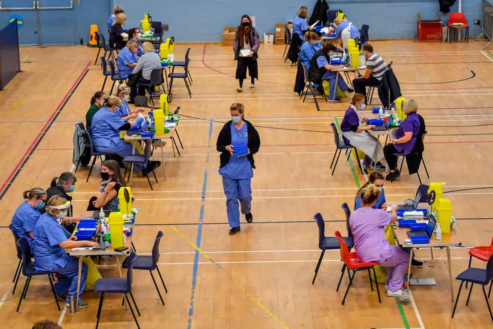 Vaccine stations are set up where care workers give out injections of the Pfizer vaccine at a coronavirus vaccination centre at Cwmbran Stadium in south Wales (Ben Birchall/PA)