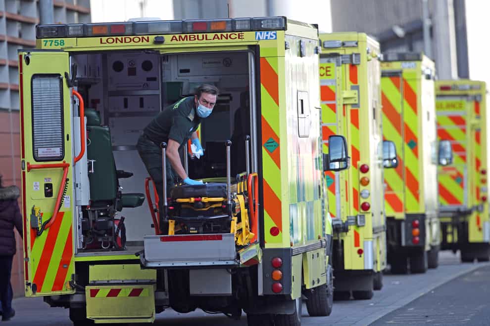 A paramedic wearing a face mask cleans the back of an ambulance at the Royal London Hospital in London (Yui Mok/PA)