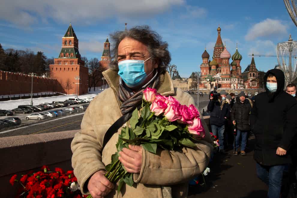 A man walks to lay flowers near where Russian opposition leader Boris Nemtsov was gunned down, in Moscow