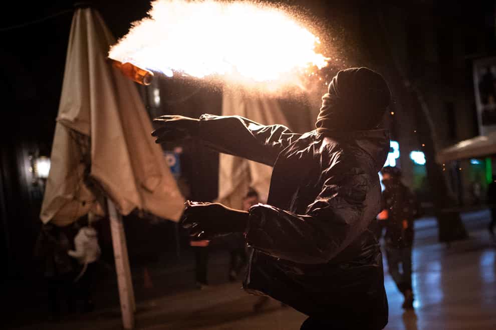 A protestor throws a molotov cocktail during clashes in Barcelona