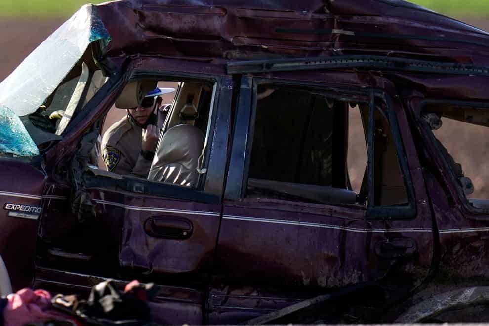 A California Highway Patrol officer examines the scene of a deadly crash in Holtville, California