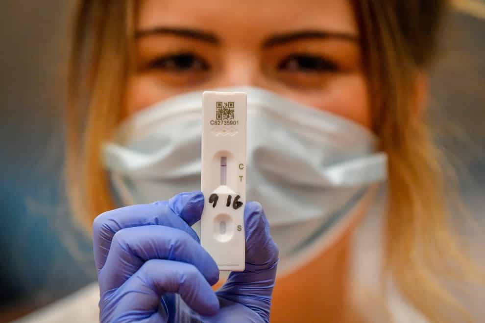 A health worker holds up a coronavirus testing device