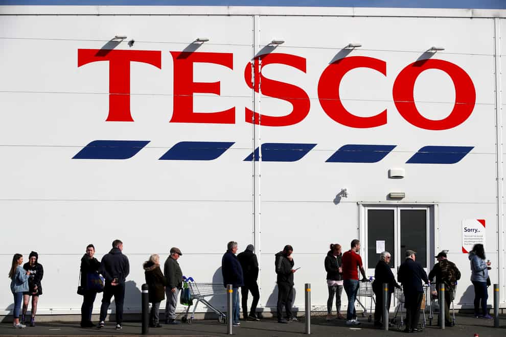 People queue outside a Tesco Extra store