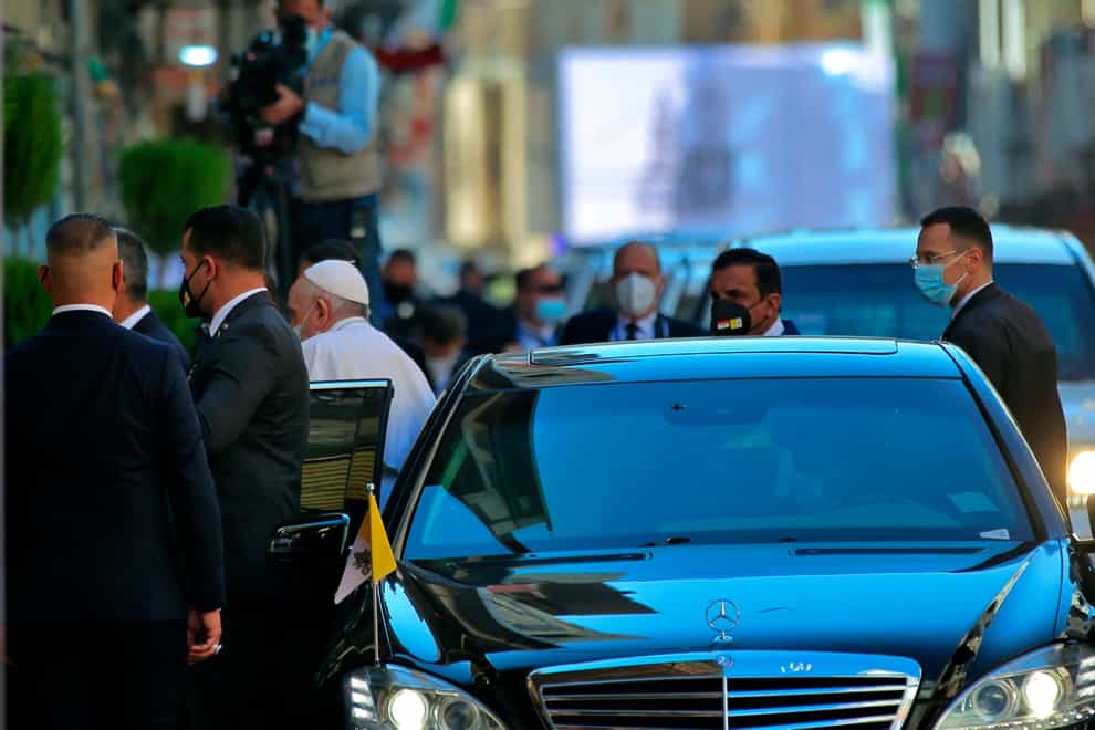 Pope Francis stepping out of a car to meet Shiite Muslim leader Grand Ayatollah Ali al-Sistani in Najaf on Saturday