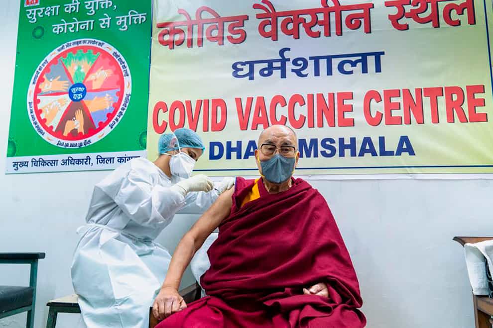 The Dalai Lama receiving a shot of the vaccine
