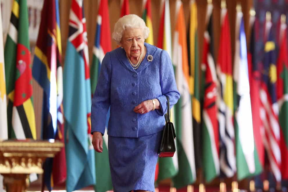 Queen in front of flags