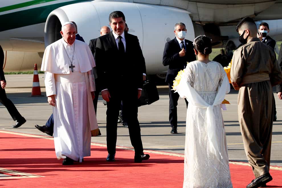 Pope Francis is welcomed by Kurdish President Nechirvan Barzani on arrival at Irbil airport