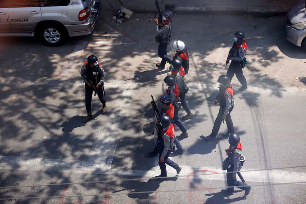 Riot police officers move in to disperse protesters during a demonstration in Yangon, Myanmar