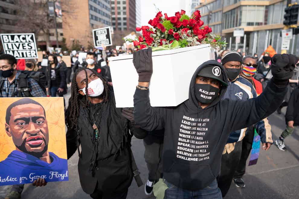 Cortez Rice, left, a friend of George Floyd, and Raj Sethuraju carried a mock coffin to mourn the death of George Floyd during a rally in Minneapolis, Minnesota
