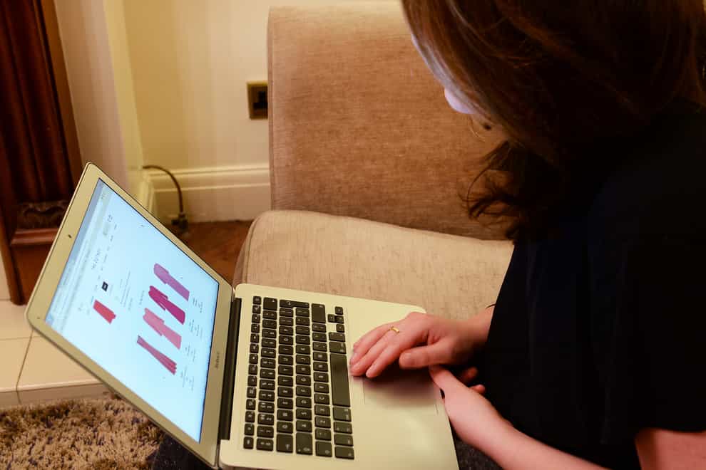 A woman looks at an online shopping website on a laptop (John Stillwell/PA)