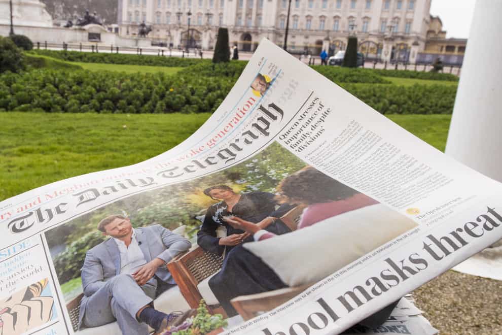 A British newspaper flutters in the wind outside Buckingham Palace