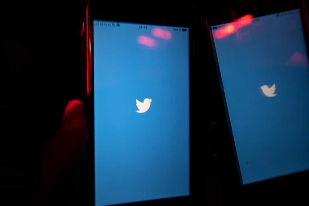A mobile phone user turns on the Twitter application on his smartphone in Moscow, Russia (Alexander Zemlianichenko/AP)