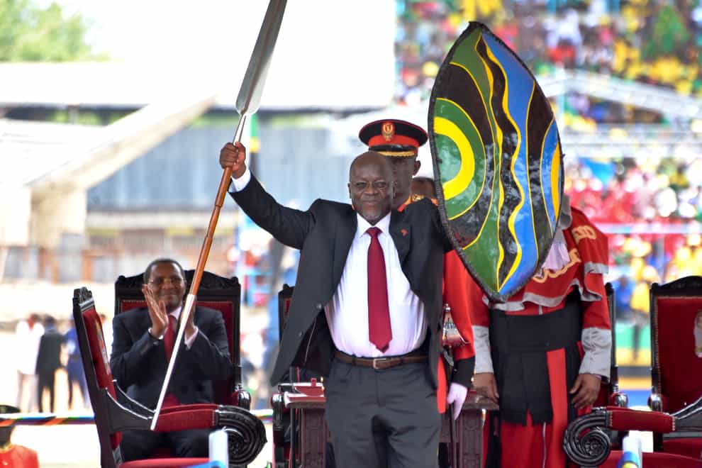 Tanzania’s President John Magufuli holds up a ceremonial spear and shield (Khaifan Said/AP)