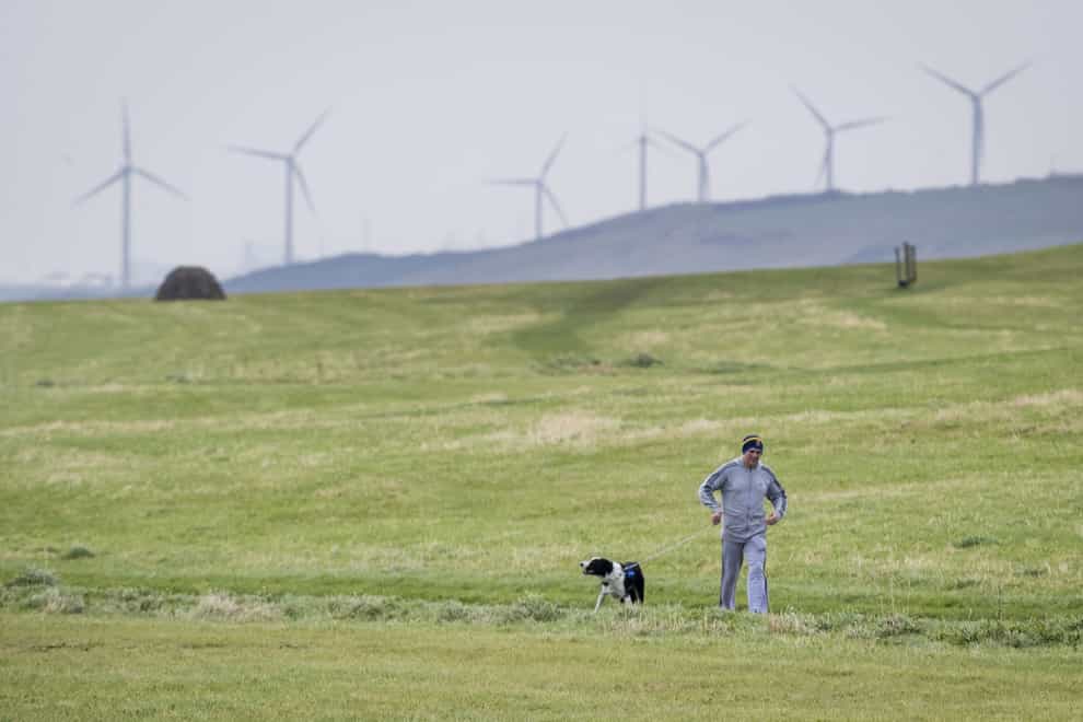 A man walking his dog near Whitehaven in Cumbria where plans for a coal mine have caused controversy (Danny Lawson/PA)