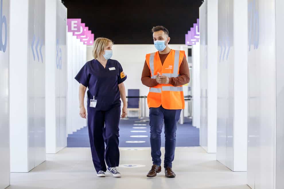 Dr Amir Khan chats to ward manager Sue Peak during a tour of the Elland Road vaccine centre in Leeds