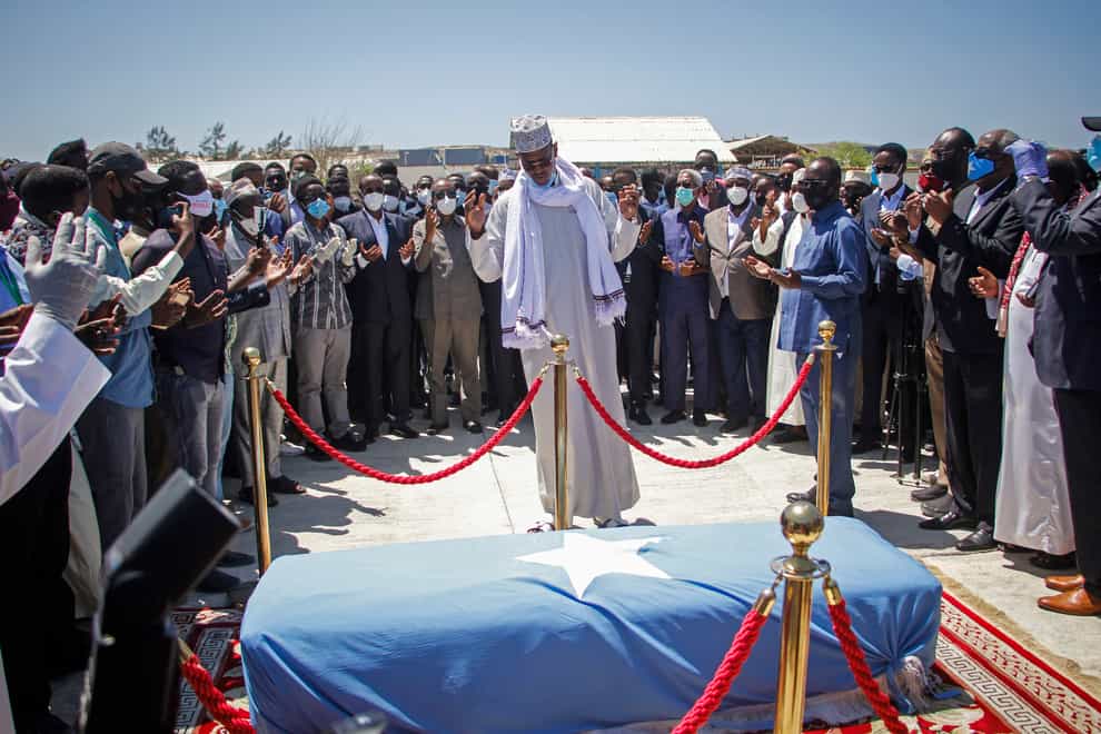 Former Somali state minister for presidential affairs Abdulkadir Moallim Noor, centre, prays over the body of former president Ali Mahdi Mohamed (Farah Abdi Warsameh/AP)