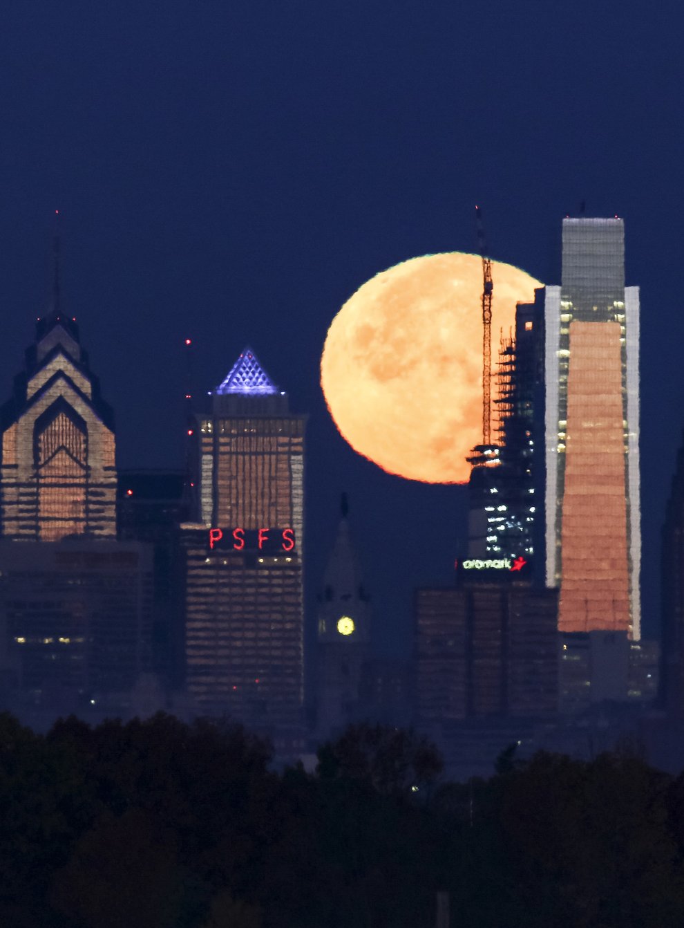 A supermoon sets behind the Philadelphia skyline (Joseph Kaczmarek/AP)