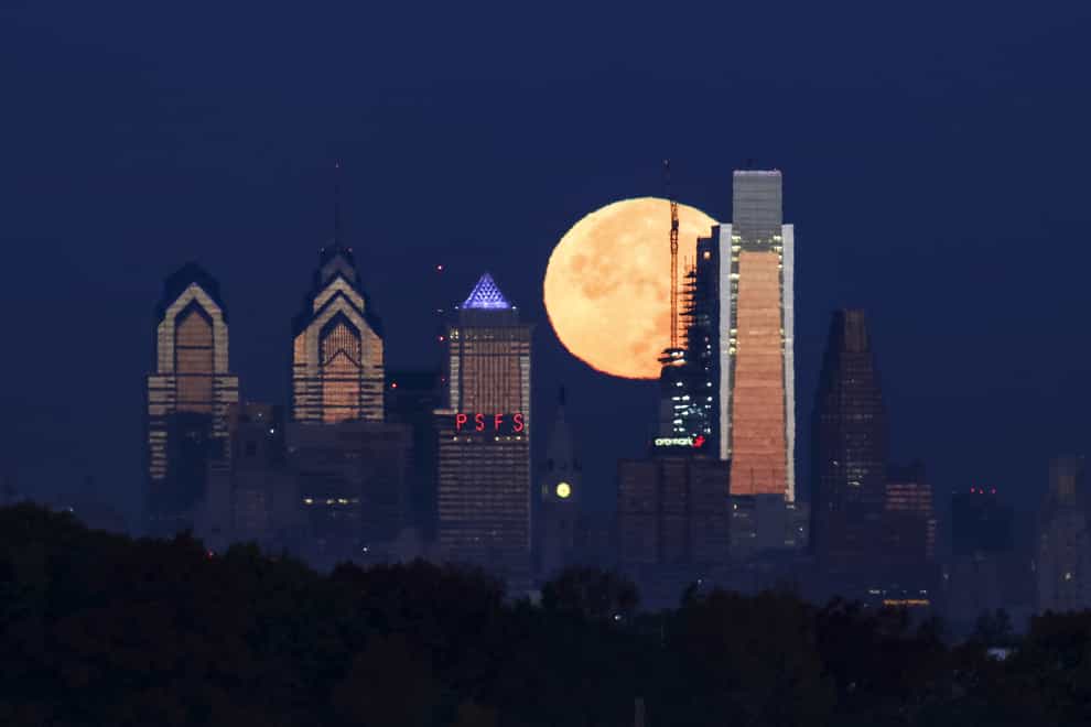 A supermoon sets behind the Philadelphia skyline (Joseph Kaczmarek/AP)