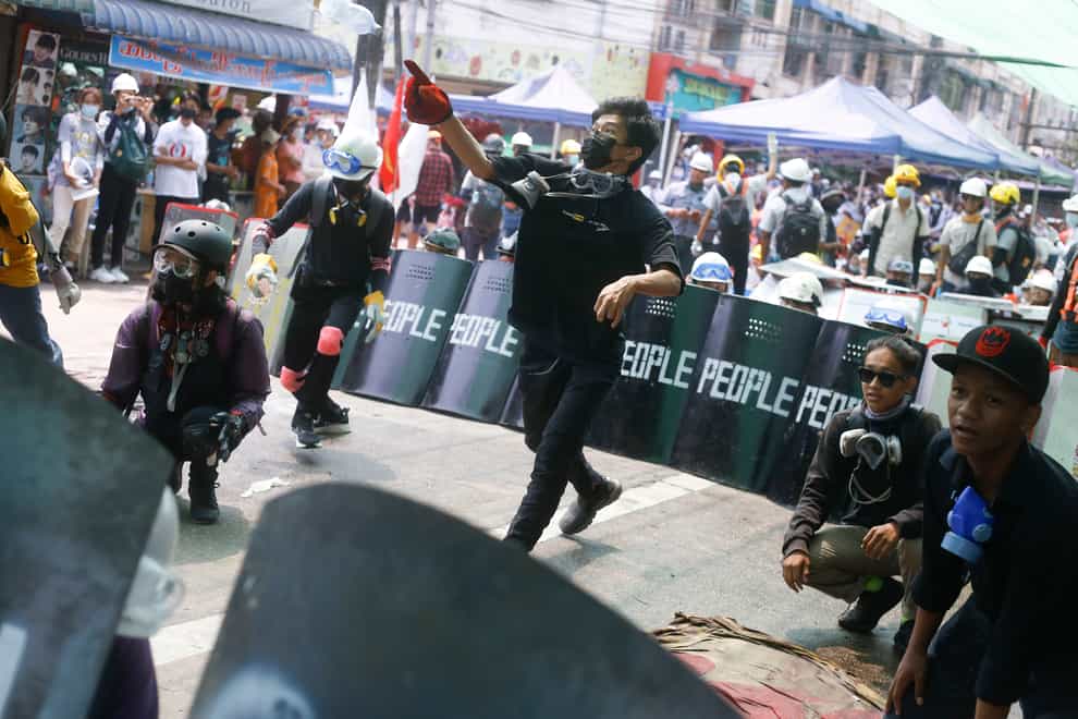 Anti-coup protesters practise a defence formation with makeshift shields during a demonstration in Yangon, Myanmar