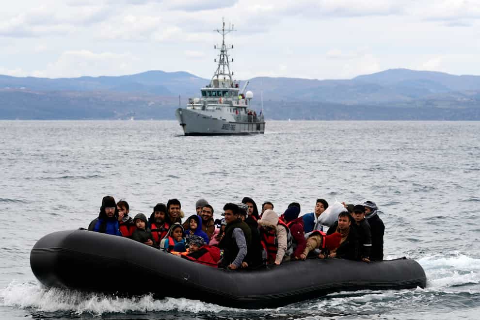 Migrants arrive aboard a dinghy accompanied by a Frontex vessel at the village of Skala Sikaminias, on the Greek island of Lesbos