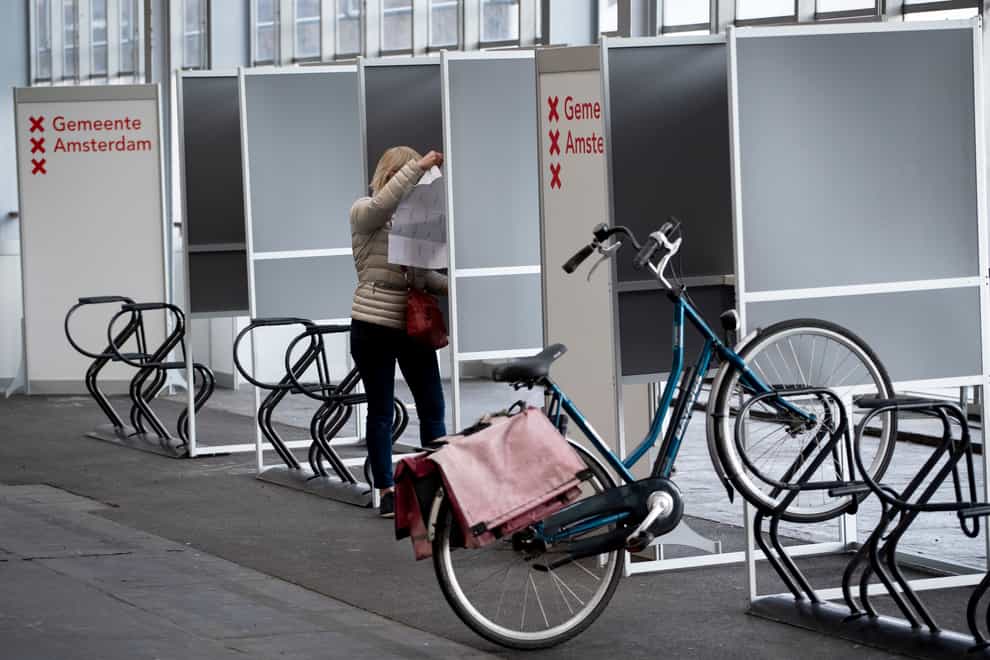 A woman prepares to cast her ballot at a ride-through polling station for bicycles in Amsterdam