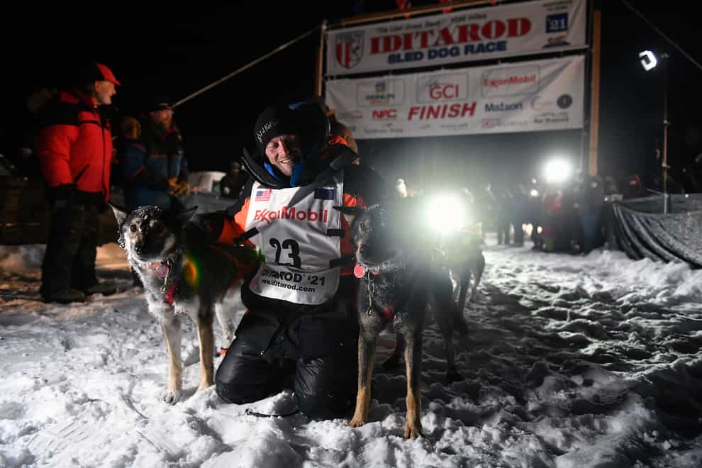 Dallas Seavey poses with his dogs after crossing the finish line