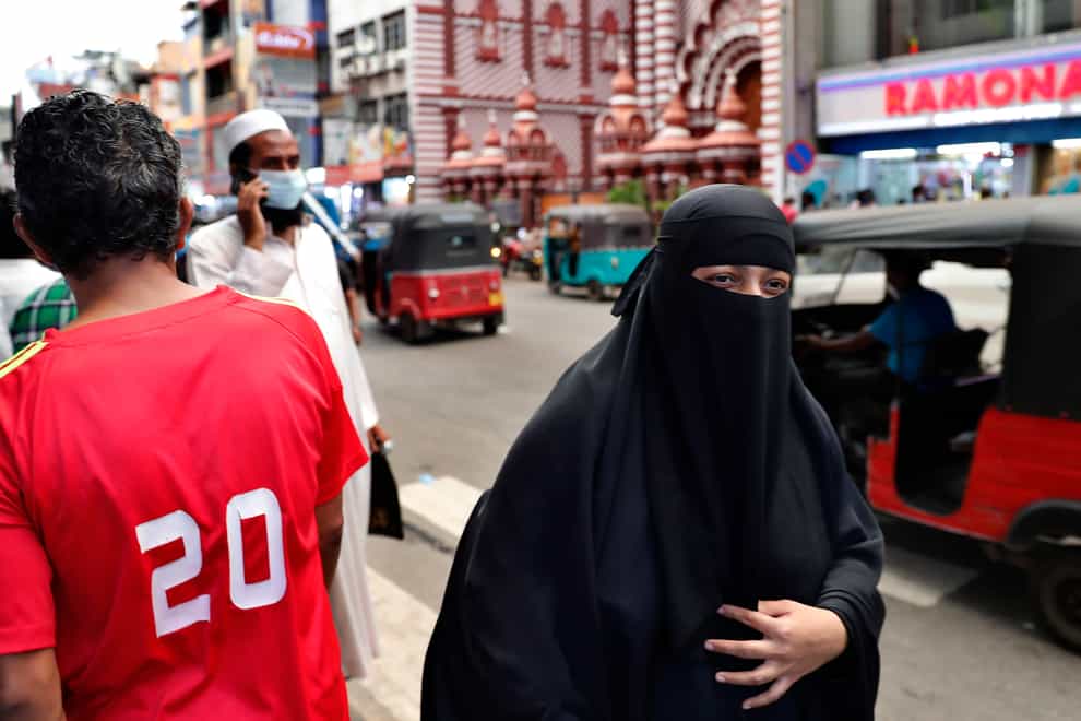 A Sri Lankan Muslim woman walks in a street of Colombo, Sri Lanka (Eranga Jayawardena/AP)