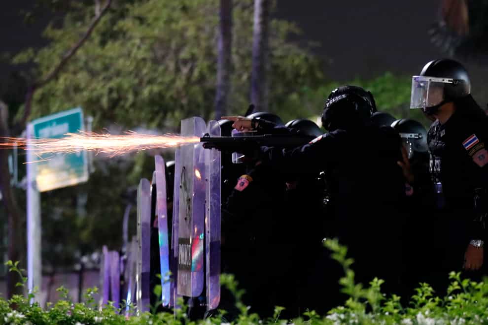 Sparks fly from the barrel of a gun used by riot police to disperse protesters