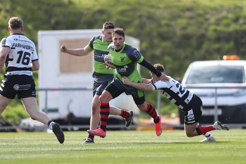 West Wales Raiders’ Gavin Henson (centre) holds off Widnes Vikings’ Lewis Else