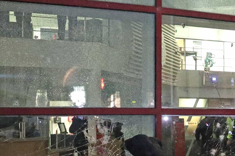 A protester kicks a smashed Bridewell police station window in Bristol