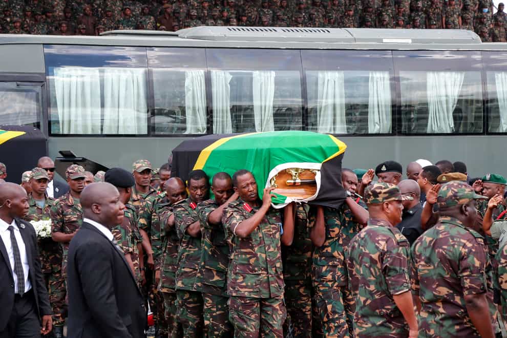 Members of the military carry the body of former president John Magufuli