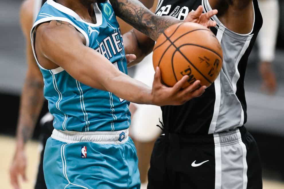 Charlotte Hornets’ Malik Monk (left) shoots against San Antonio Spurs’ Rudy Gay