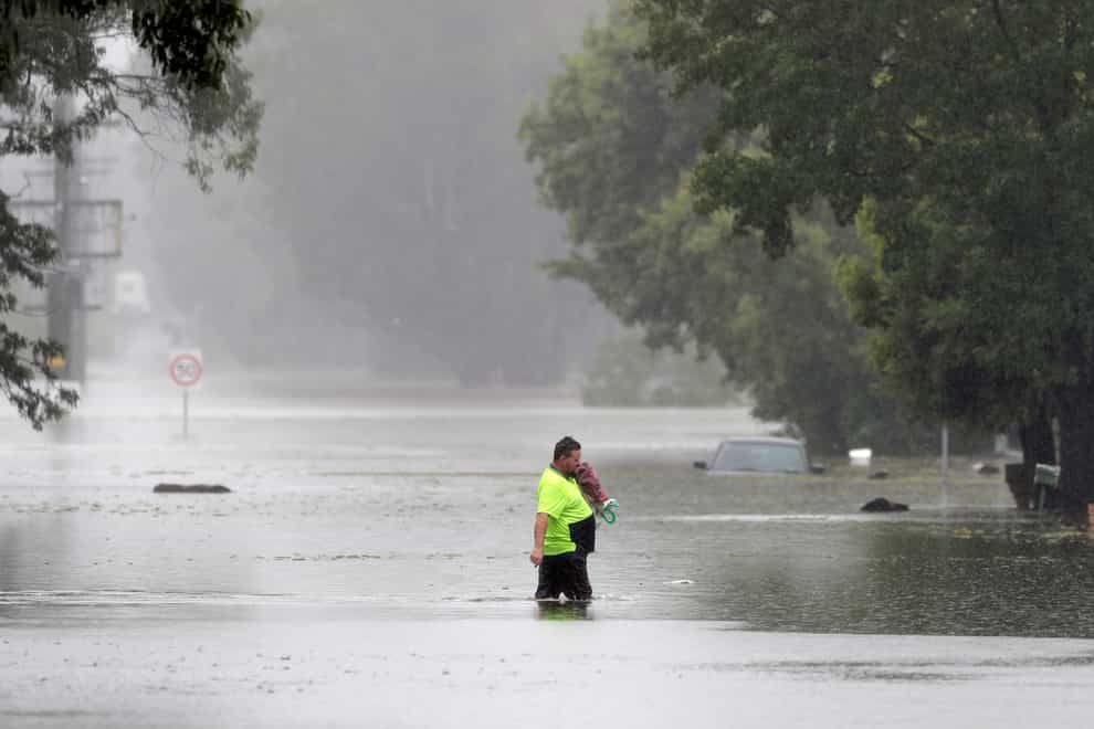 A man walks across a flooded street