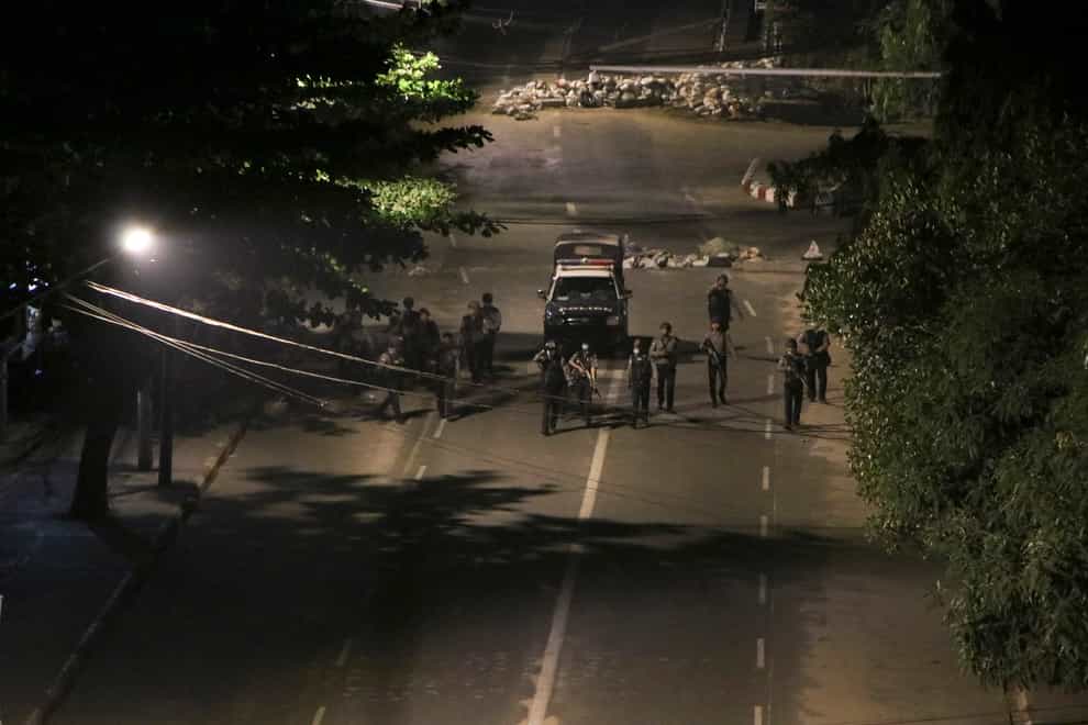 Armed police patrol a street in Yangon, Myanmar