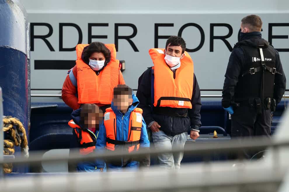 A young family among a group of people thought to be migrants are brought in to Dover, Kent