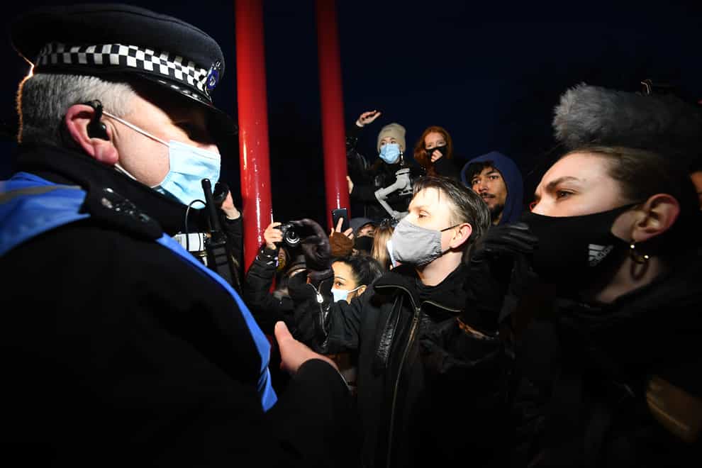 Members of the crowd talk to the police as they gather in memory of Sarah Everard in south London on March 13