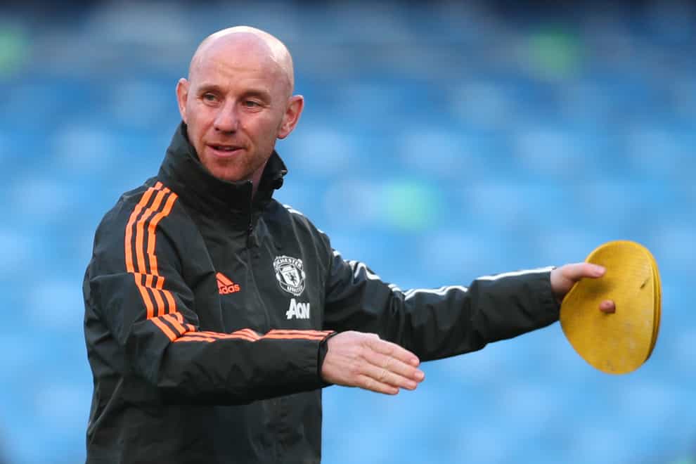 Manchester United first-team development coach Nicky Butt puts out cones for a pre-match warm-up