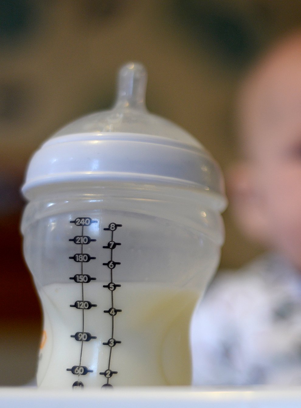 Baby looks at milk bottle
