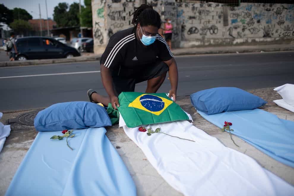 A demonstrator places a Brazil national flag on a mattress