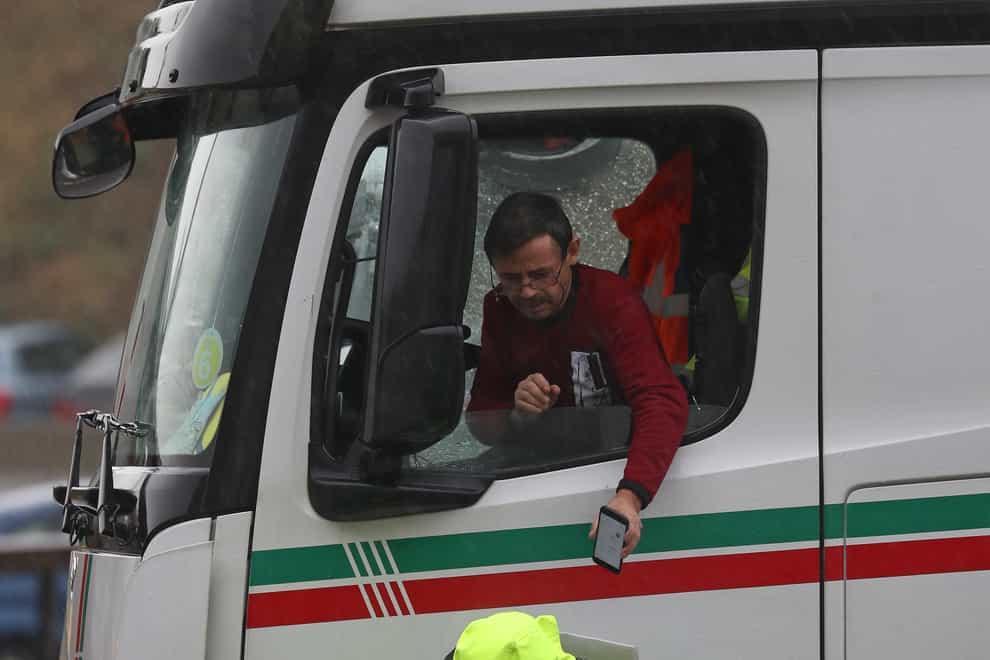 A lorry driver leans out of his window to scan a document