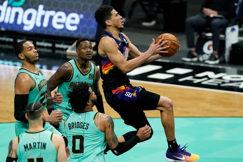 Phoenix Suns guard Devin Booker scores past the Charlotte Hornets